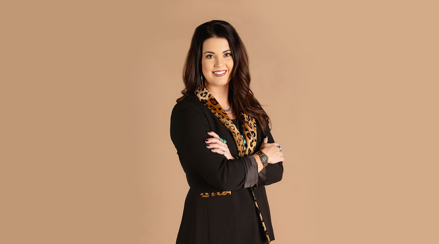 A photo of Shelbi Tidwell posing and wearing a black and cheetah long-sleeved shirt.